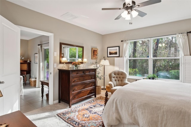 bedroom featuring multiple windows, ceiling fan, and light tile patterned flooring