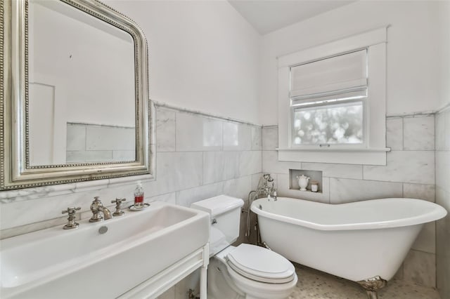 bathroom with tile walls, sink, a bathtub, and toilet