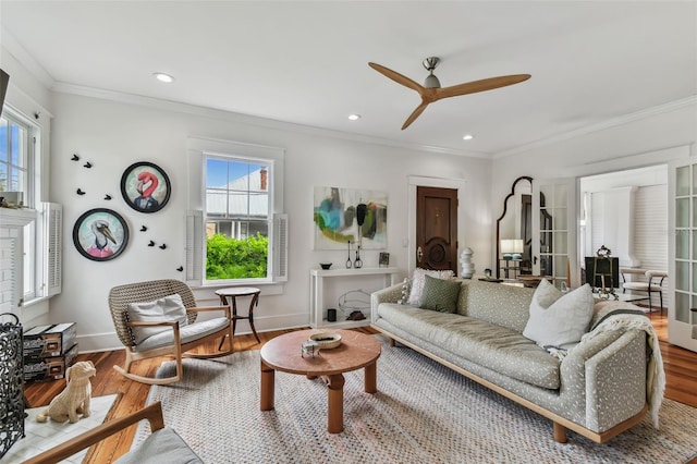 living room featuring hardwood / wood-style floors, crown molding, and ceiling fan