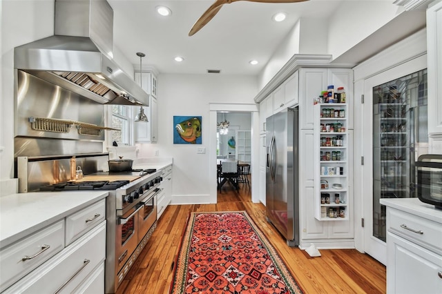 kitchen with ceiling fan, stainless steel appliances, island exhaust hood, and white cabinets