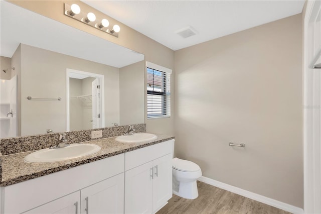 bathroom with hardwood / wood-style flooring, vanity, and toilet