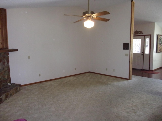 unfurnished living room with carpet floors, a fireplace, vaulted ceiling, and ceiling fan