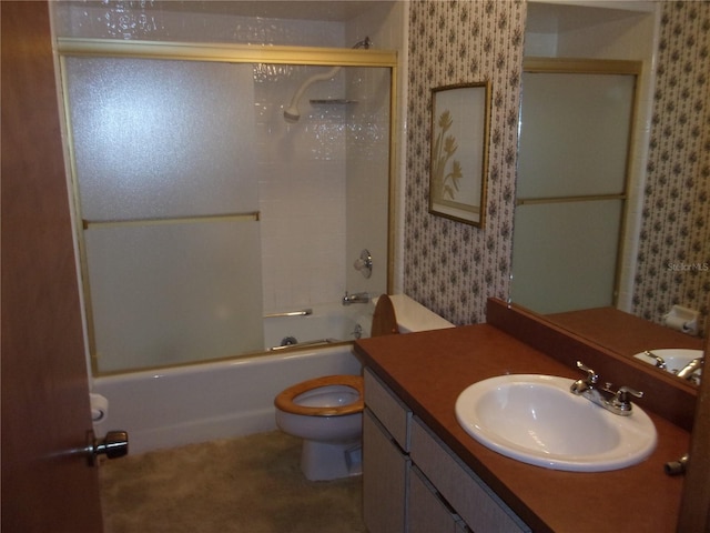 full bathroom with bath / shower combo with glass door, vanity, and toilet