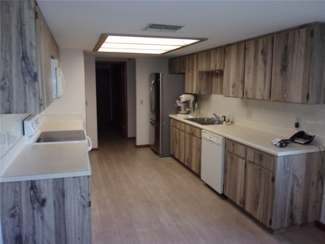 kitchen with white appliances, sink, and light wood-type flooring