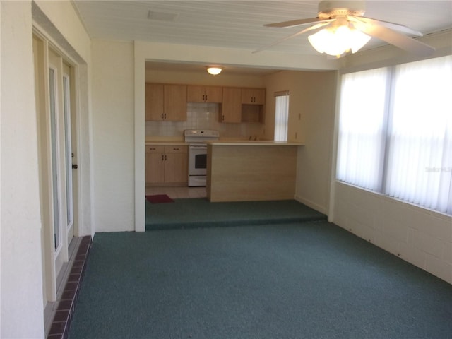 kitchen with a wealth of natural light, white electric range oven, light brown cabinets, and decorative backsplash