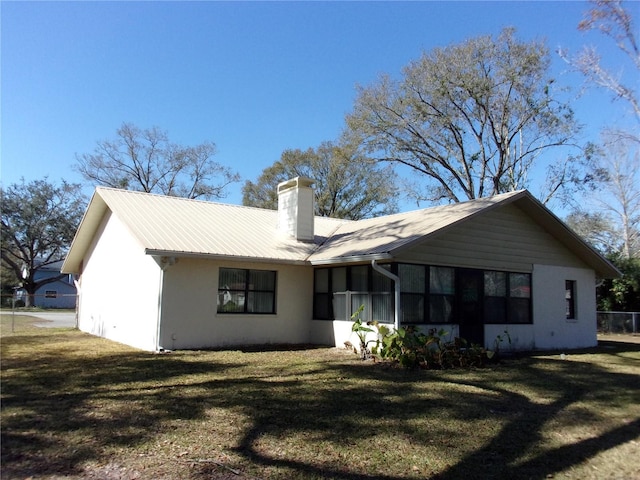 back of house with a lawn and a sunroom