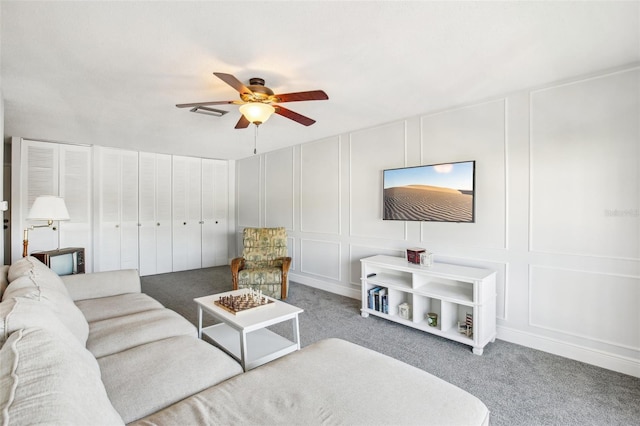 carpeted living room with ceiling fan