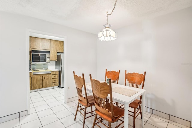 dining room with a textured ceiling and light tile patterned floors