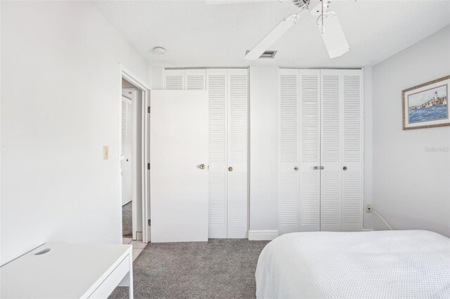 carpeted bedroom featuring two closets and ceiling fan