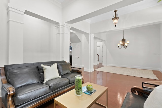 living room featuring ornate columns, ornamental molding, hardwood / wood-style flooring, and a chandelier