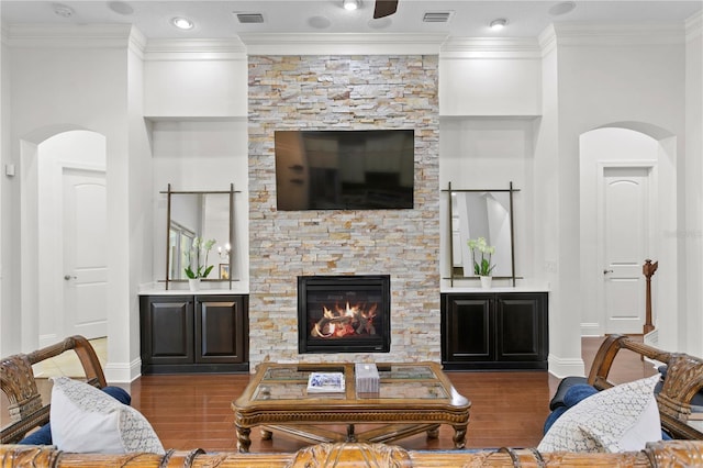 living room with a fireplace, wood-type flooring, and ornamental molding