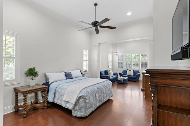 bedroom with dark hardwood / wood-style flooring, crown molding, ceiling fan, and a towering ceiling