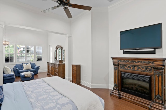 bedroom featuring ornamental molding, dark wood-type flooring, and ceiling fan with notable chandelier