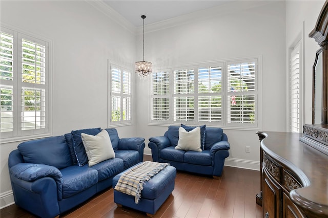 living room with dark hardwood / wood-style flooring, ornamental molding, and an inviting chandelier