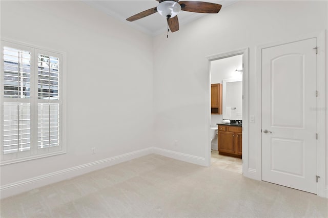 spare room featuring crown molding, light carpet, and ceiling fan