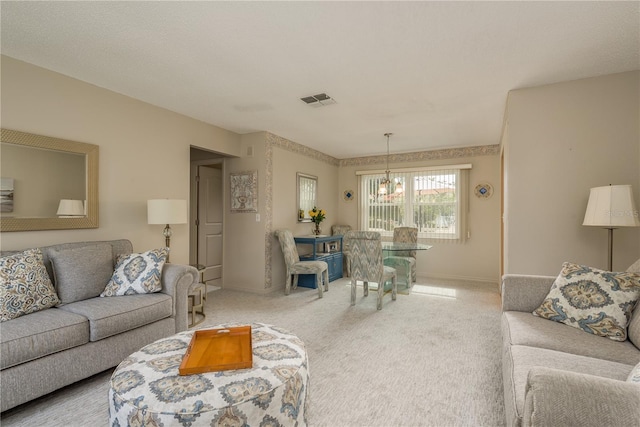 carpeted living room featuring an inviting chandelier