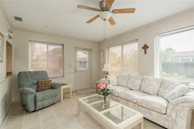 tiled living room featuring ceiling fan, ornamental molding, and plenty of natural light