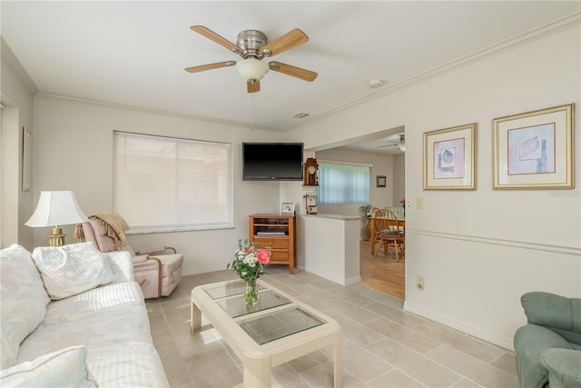 tiled living room featuring ornamental molding and ceiling fan