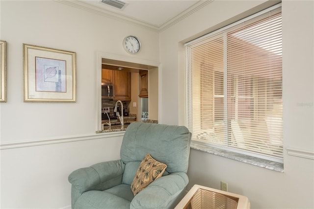 living area with ornamental molding and sink