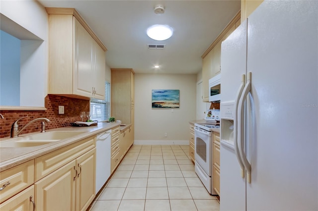 kitchen featuring sink, white appliances, light tile patterned floors, cream cabinets, and decorative backsplash