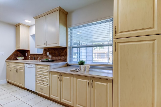 kitchen with tasteful backsplash, white dishwasher, light tile patterned flooring, and sink