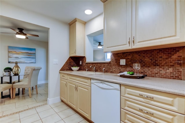 kitchen featuring dishwasher, sink, backsplash, light tile patterned floors, and cream cabinetry