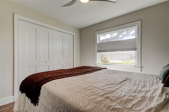 bedroom featuring hardwood / wood-style flooring, ceiling fan, and a closet