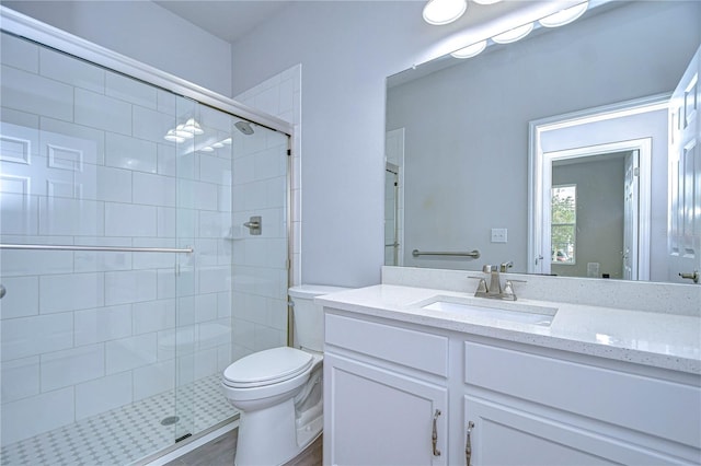 bathroom featuring an enclosed shower, vanity, and toilet