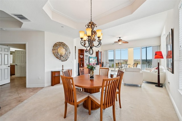 dining space with an inviting chandelier, light colored carpet, ornamental molding, and a raised ceiling