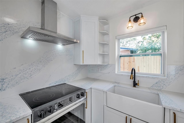 kitchen with white cabinetry, stainless steel electric range oven, wall chimney range hood, and decorative backsplash