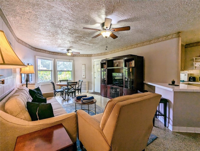 living room featuring a tile fireplace, ceiling fan, and a textured ceiling