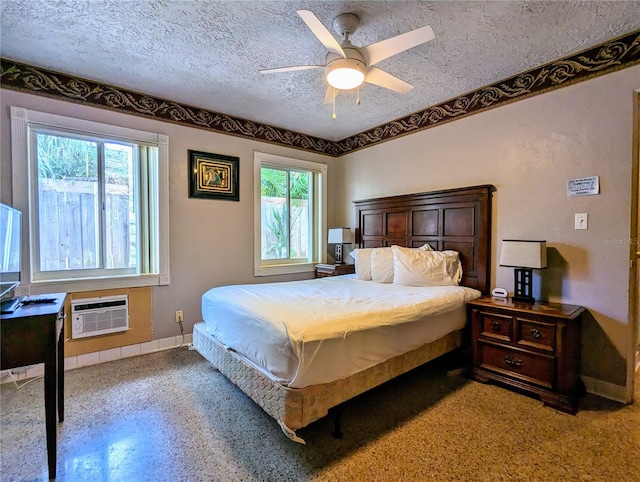 bedroom with ceiling fan, a wall unit AC, and a textured ceiling