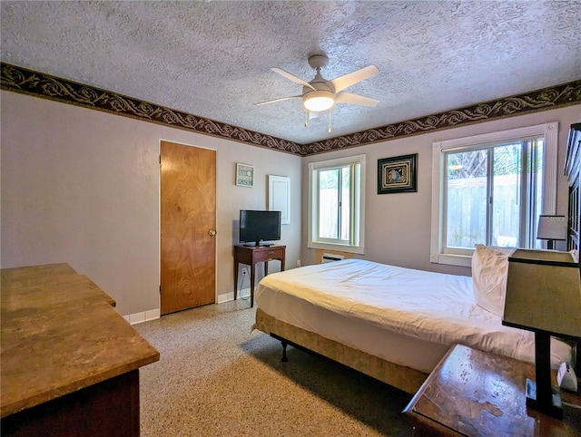 bedroom featuring multiple windows, ceiling fan, and a textured ceiling