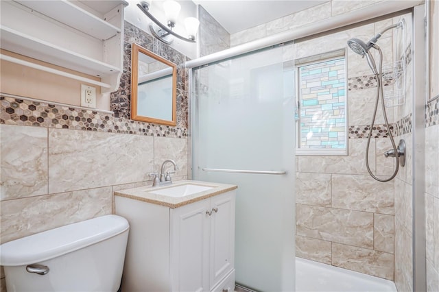 bathroom with vanity, a tile shower, tile walls, and toilet