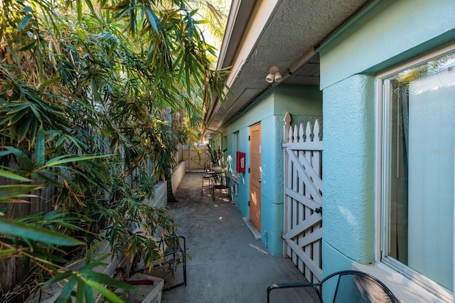 view of side of property featuring a patio, fence, and stucco siding