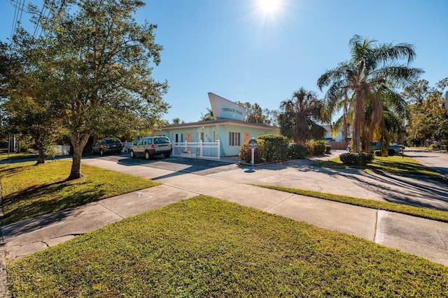 view of front of property with concrete driveway and a front lawn