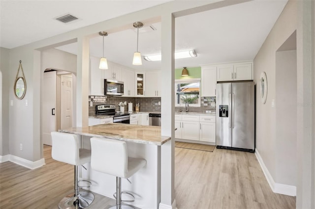 kitchen with white cabinets, glass insert cabinets, and stainless steel appliances