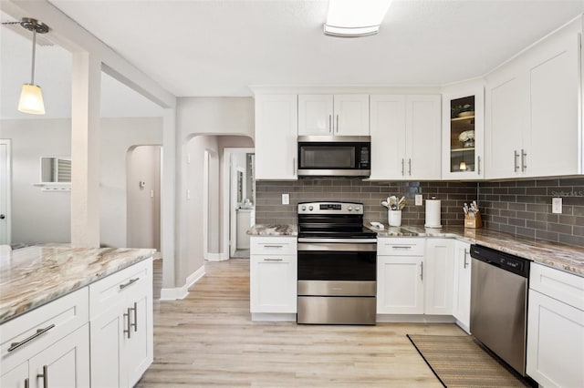 kitchen featuring appliances with stainless steel finishes, glass insert cabinets, and white cabinetry