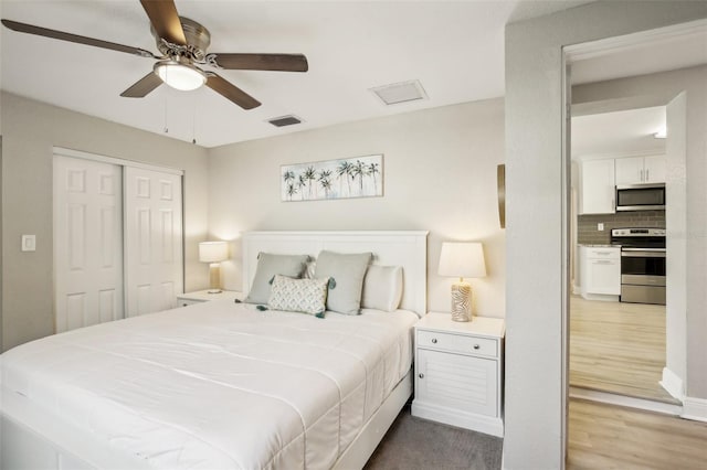 bedroom featuring a closet, visible vents, ceiling fan, and wood finished floors