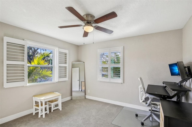 office area with baseboards, a textured ceiling, a ceiling fan, and light colored carpet