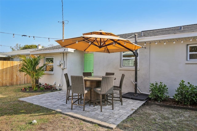 view of patio / terrace featuring an outdoor bar and fence