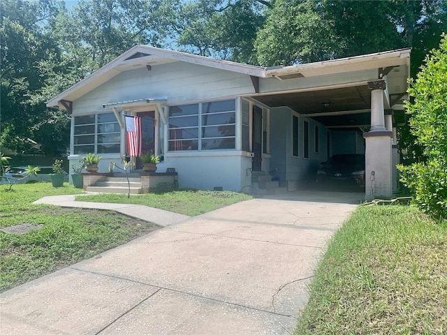 view of front of house featuring a carport and a front yard