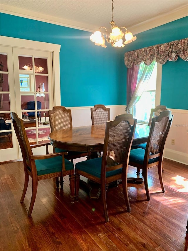 dining space with hardwood / wood-style floors, a textured ceiling, and a chandelier