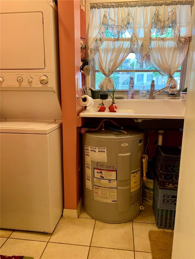 laundry area with light tile patterned flooring, stacked washing maching and dryer, and water heater