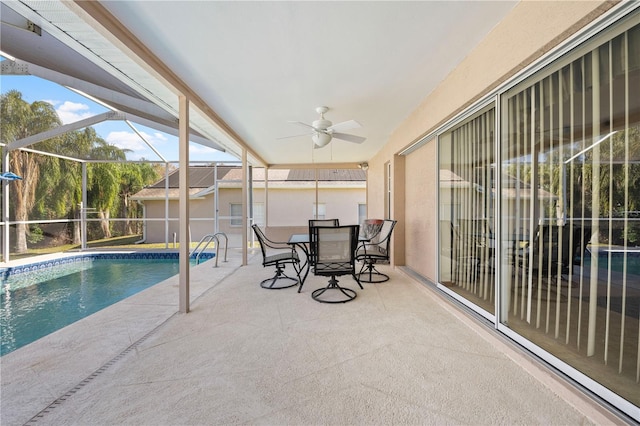 view of swimming pool featuring ceiling fan, a lanai, and a patio area