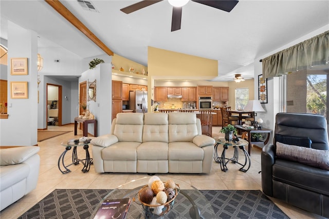 tiled living room with ceiling fan, lofted ceiling with beams, and a wealth of natural light