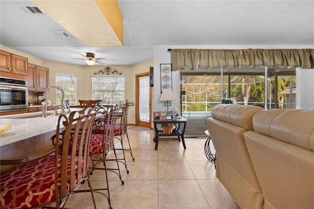 interior space with sink, light tile patterned floors, and ceiling fan