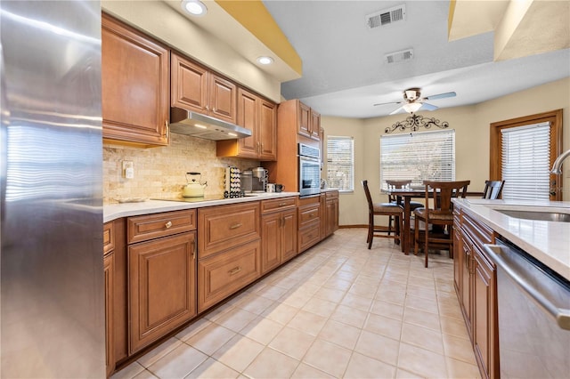 kitchen featuring tasteful backsplash, sink, light tile patterned floors, and appliances with stainless steel finishes