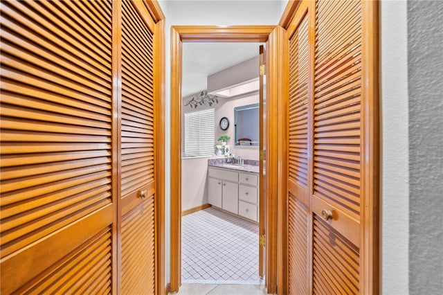 hallway with light tile patterned flooring and sink