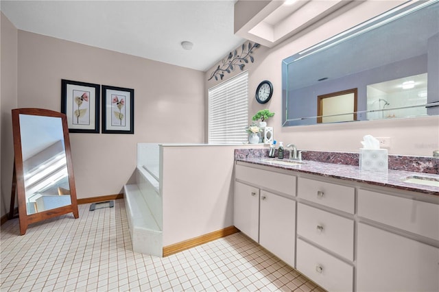 bathroom with walk in shower, vanity, and tile patterned flooring